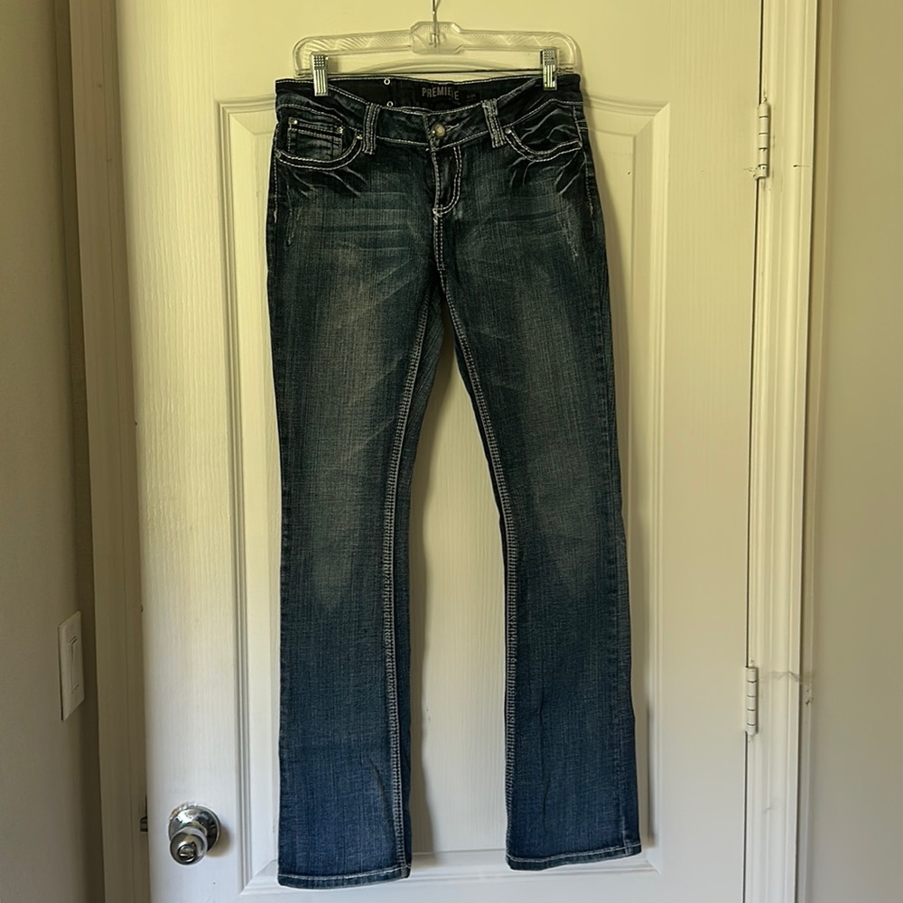Premiere slim boot cut low rise jeans with rhinestone button details. R5/6